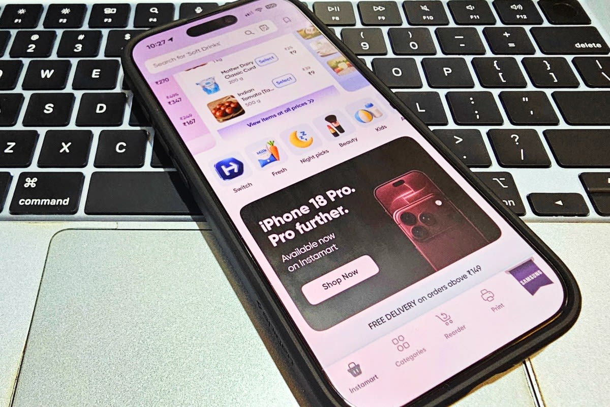 Person holding new iPhone with delivery app open on phone screen in India