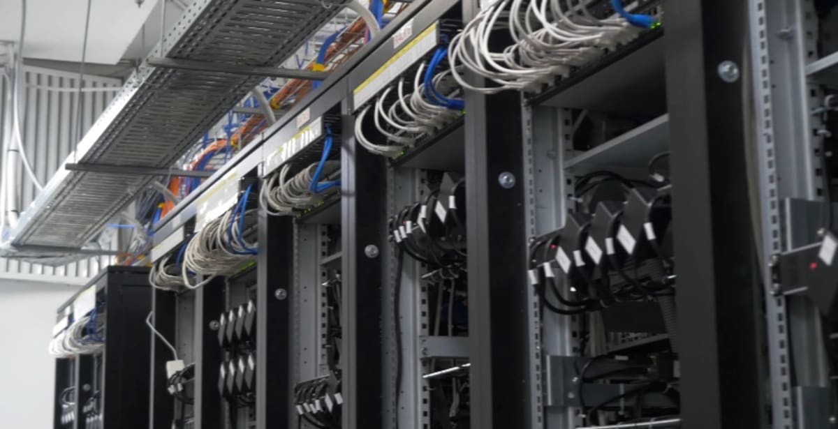 ** Modern quantum computing server room with blue glowing technology infrastructure representing energy-efficient AI systems