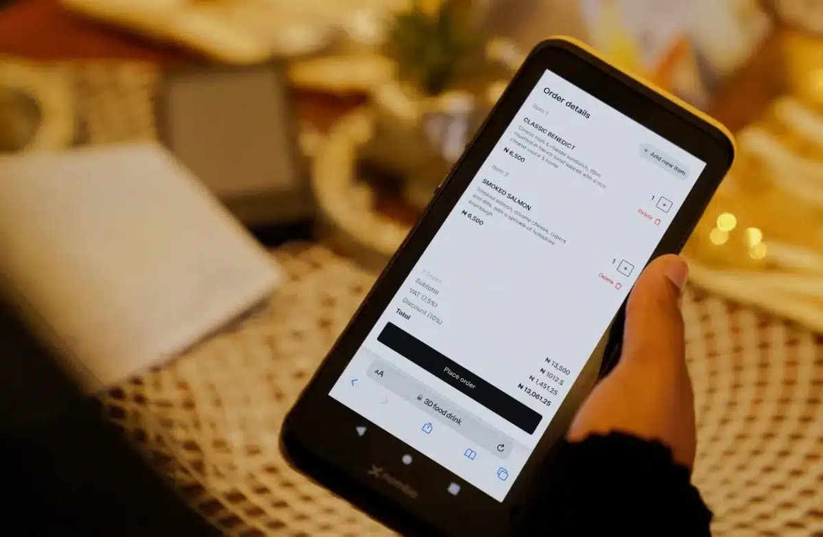 African merchant using Nomba payment terminal to process transaction for customer