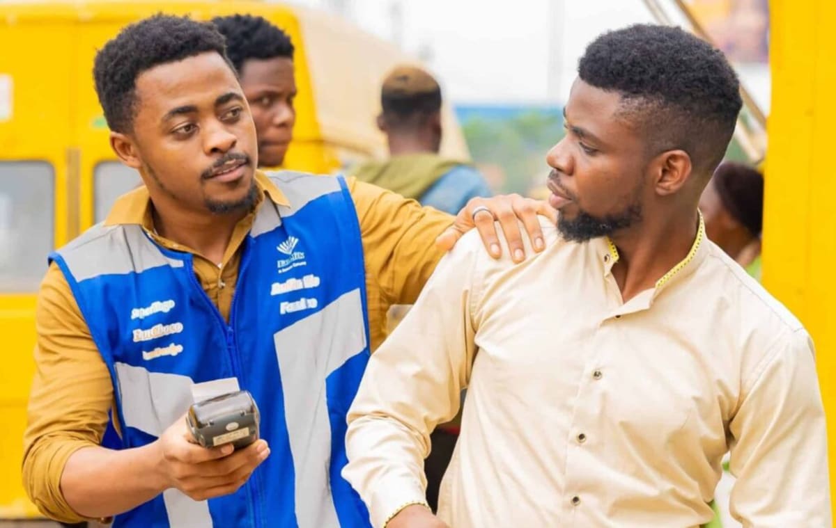 Nigerian mobile money agent helping customer with financial transaction at neighborhood kiosk