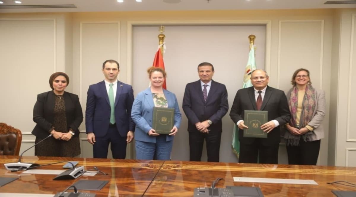 Egyptian farmers working in green fields with modern agricultural technology equipment visible