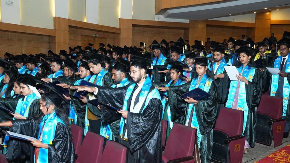 Healthcare graduates in caps and gowns celebrating at St. John's Institute convocation ceremony