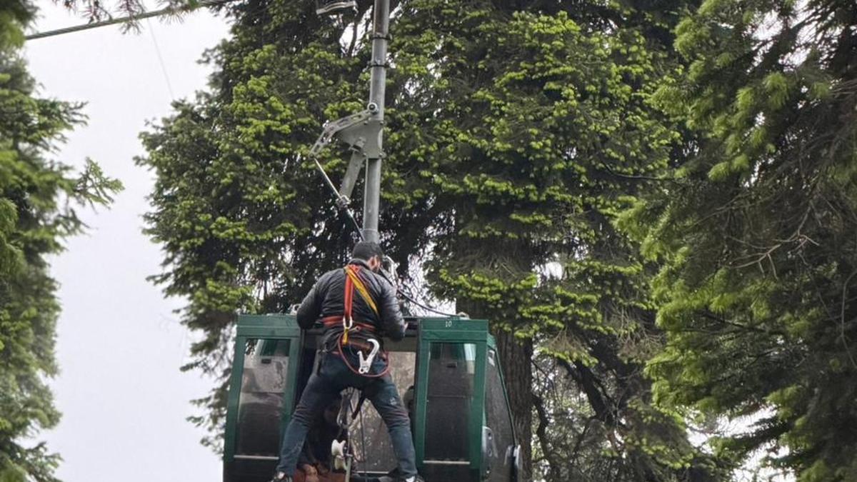 Rescue teams evacuating stranded tourists from cable car cabins high above Gulmarg mountains