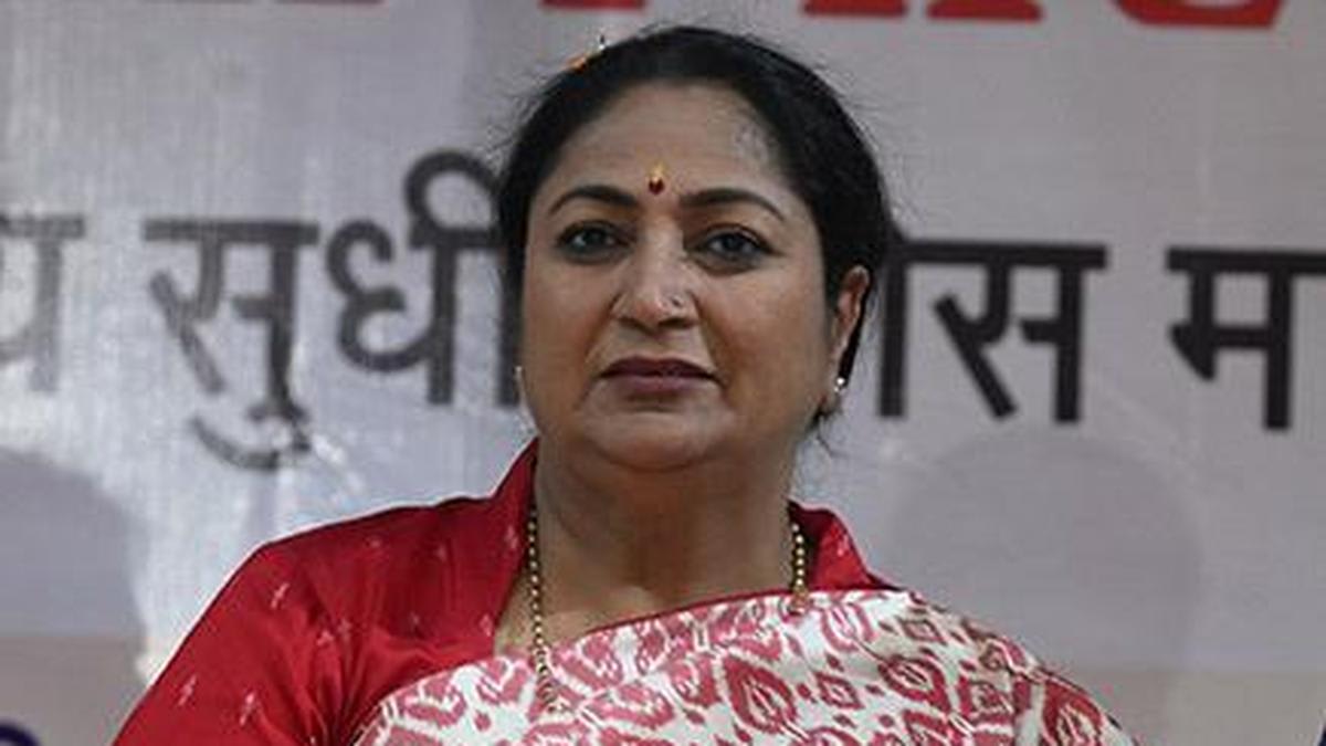 Green trees and plants in urban Delhi park with city buildings in background