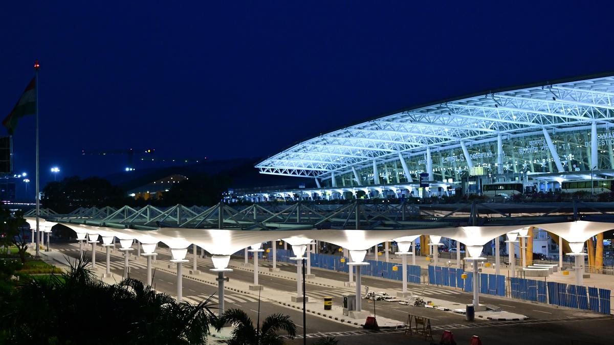 Modern airport plaza with walkways and seating area at Chennai Airport terminal entrance