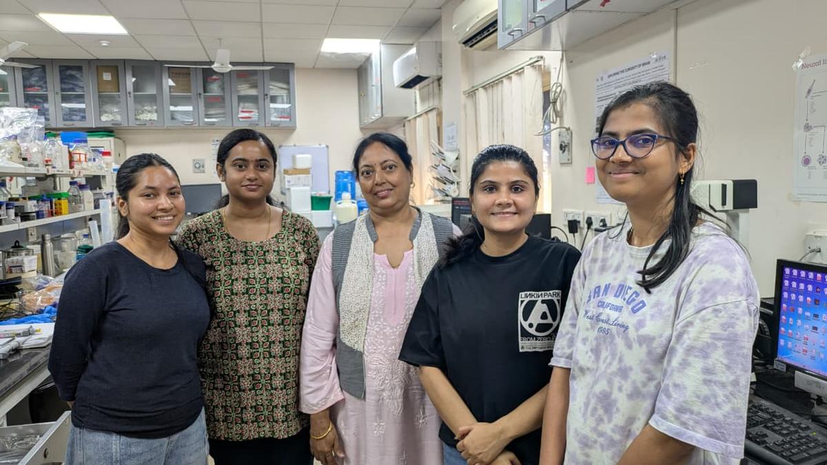 Women scientists in white lab coats conducting neuroscience research in modern laboratory in India