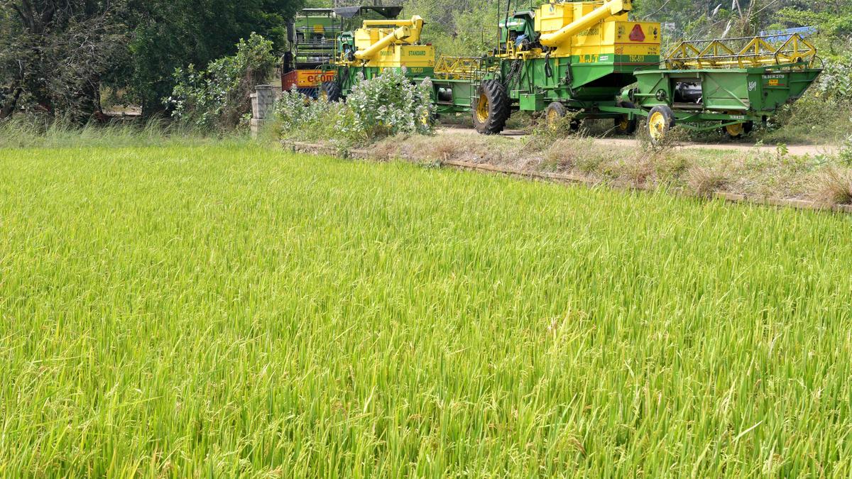 Modern combine harvester machinery at agricultural distribution event in Mandya, India