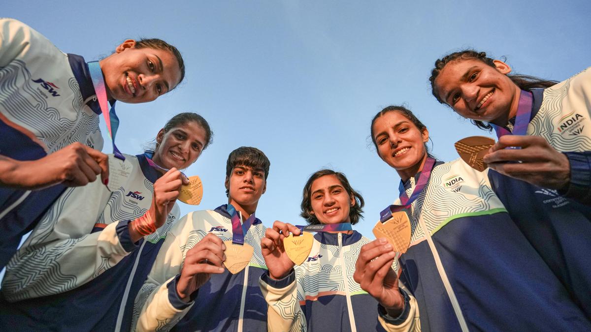 Indian athletes celebrating with medals at Commonwealth Games podium in Glasgow Scotland