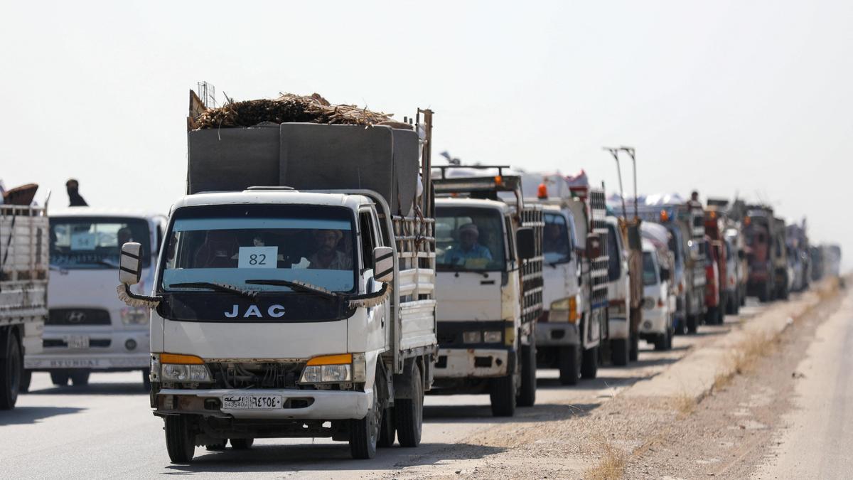 Syrian Kurdish families loading furniture onto trucks preparing to return home after displacement