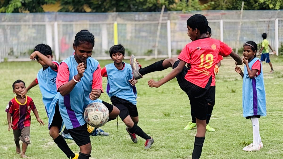 Young girls and boys practicing football together on an open field in Kolkata, India