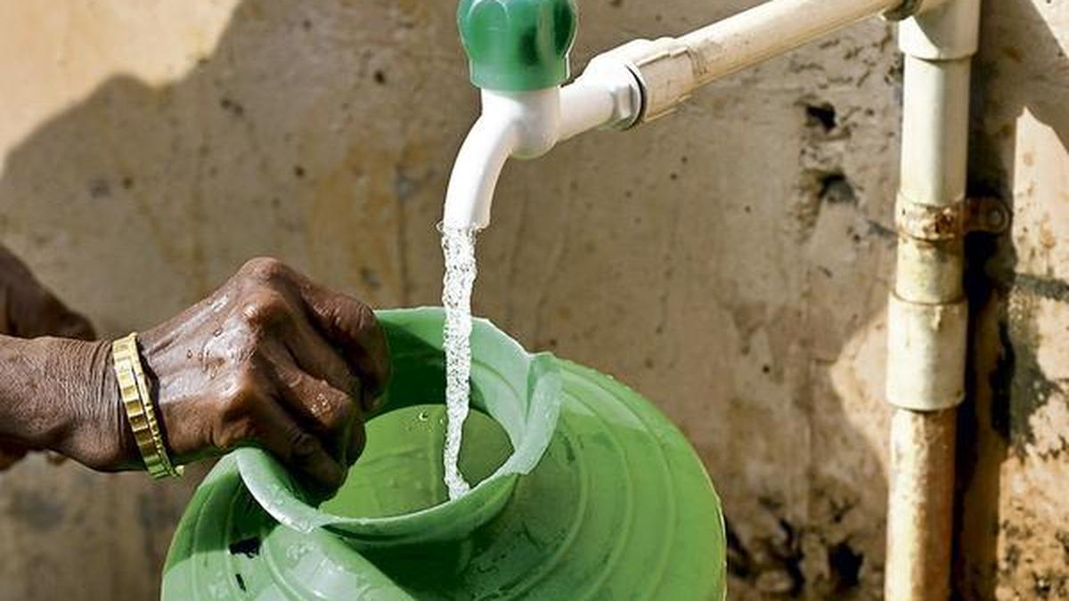 Clean water flowing from tap in Bihar rural home, family smiling nearby