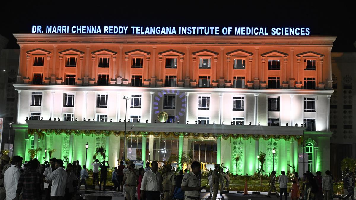 Modern multi-story hospital building with officials gathered at inauguration ceremony in Hyderabad, India