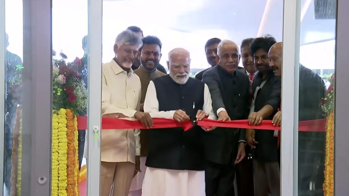 Gleaming modern glass terminal of Bhogapuram International Airport on inauguration day with crowds gathered