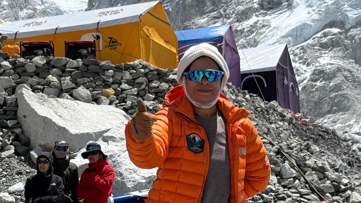 K. Jayalakshmi standing at Mount Everest Base Camp holding the Life Insurance Corporation flag