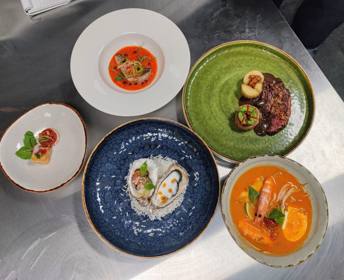 Beautifully plated Indonesian dishes at Nona Manis restaurant in warm intimate dining room setting