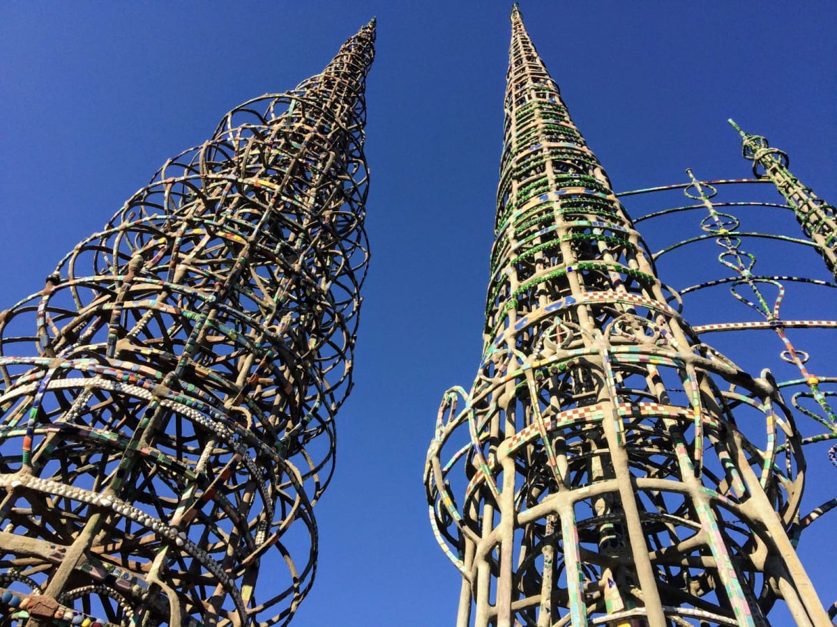 Tall decorative spires of Watts Towers covered in colorful mosaic tiles and pottery fragments