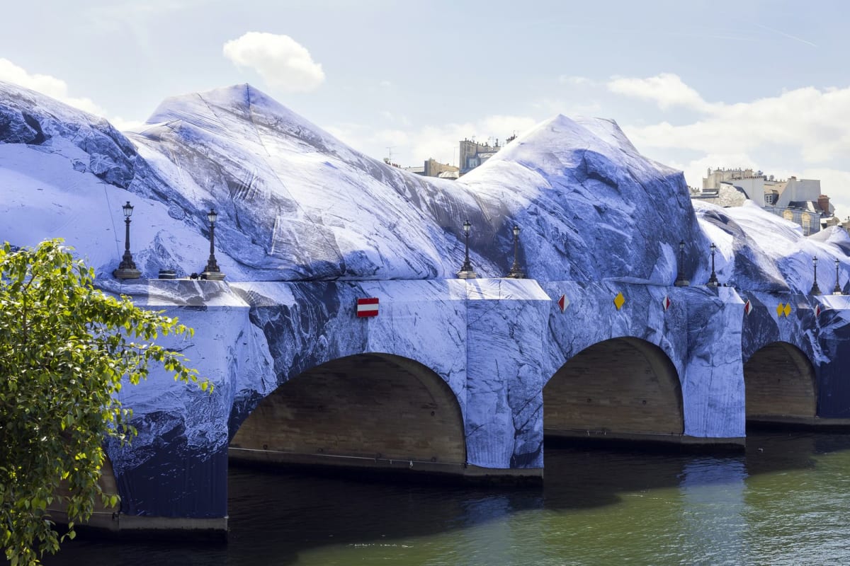 Massive inflatable cave structure covering historic Pont Neuf bridge over Seine River in Paris