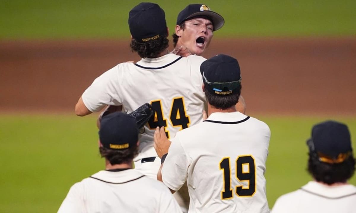Wichita State baseball player celebrating with teammates after elimination game victory at night