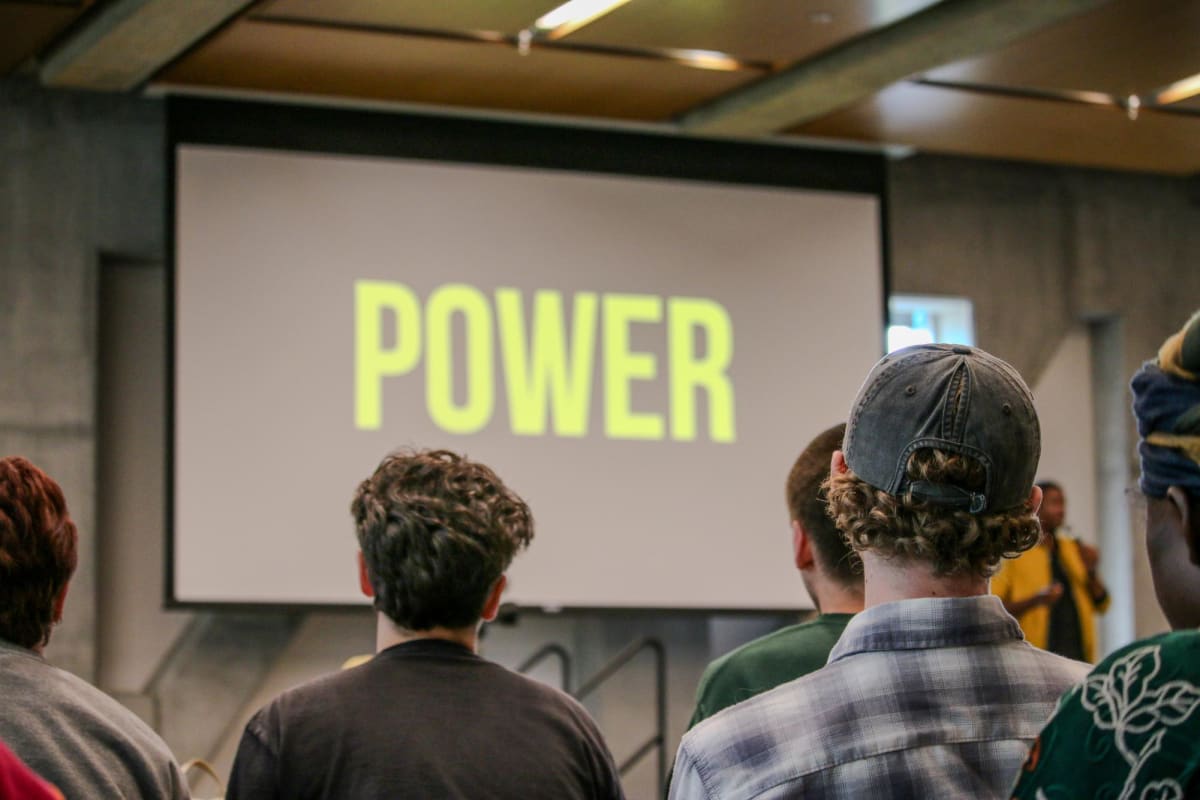 Students watching climate initiative presentation with powerpoint showing message about people power at Appalachian State University