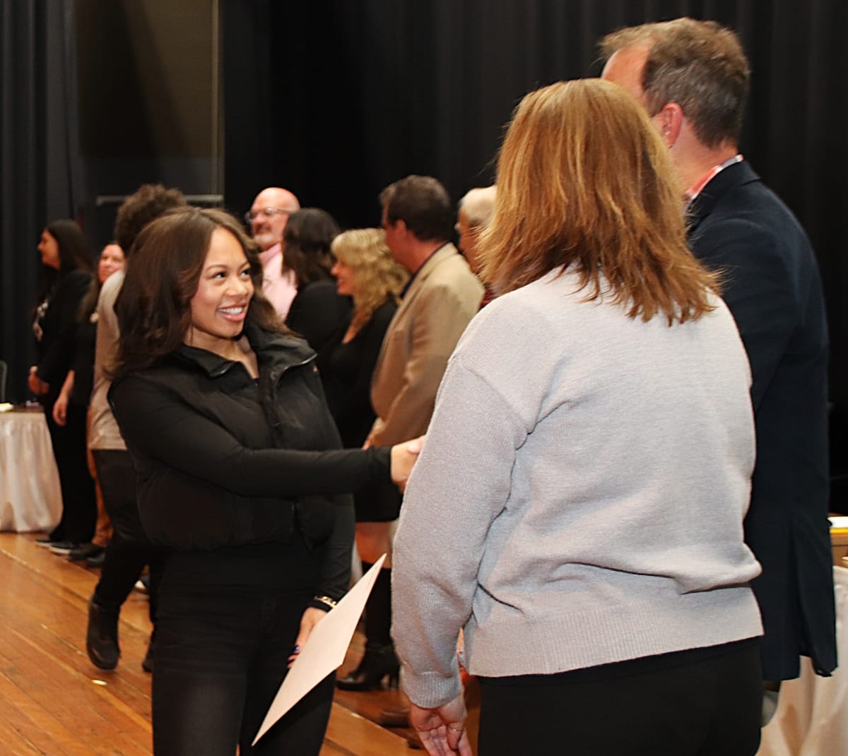 Agawam High School senior Kamiyah Ward shaking hands with school officials on stage