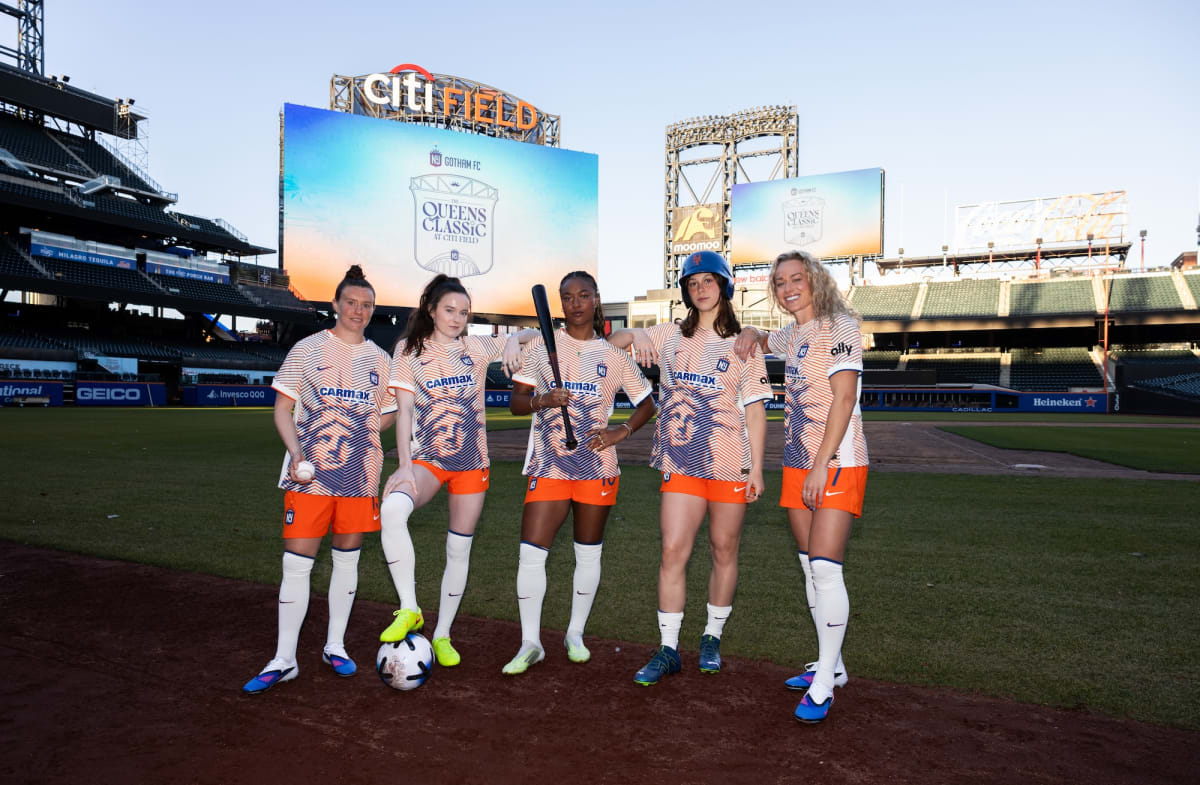 Gotham FC players celebrating on field in team uniforms at night game