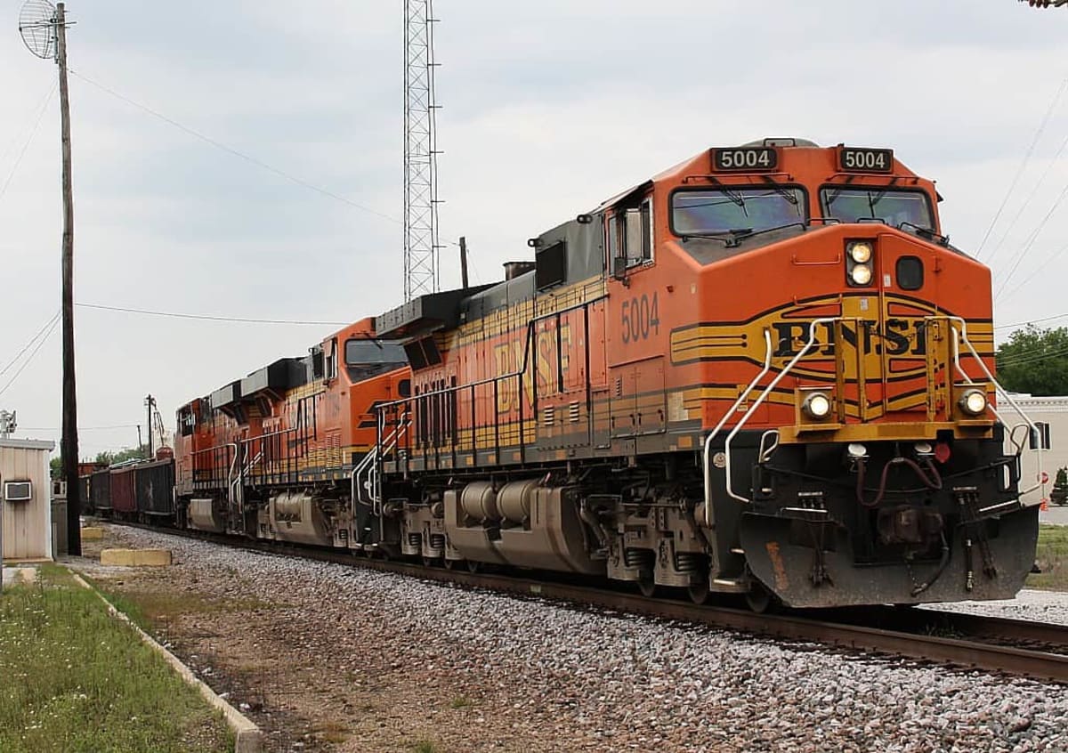 Modern high-speed train traveling through lush Central American landscape with mountains in background