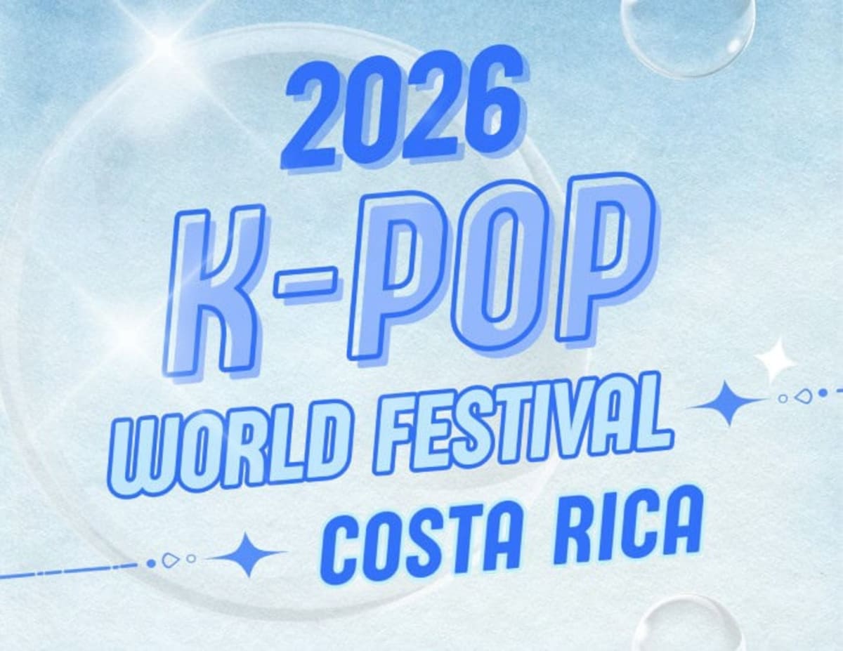 Young performers in colorful outfits dancing K-pop choreography on university stage in Costa Rica