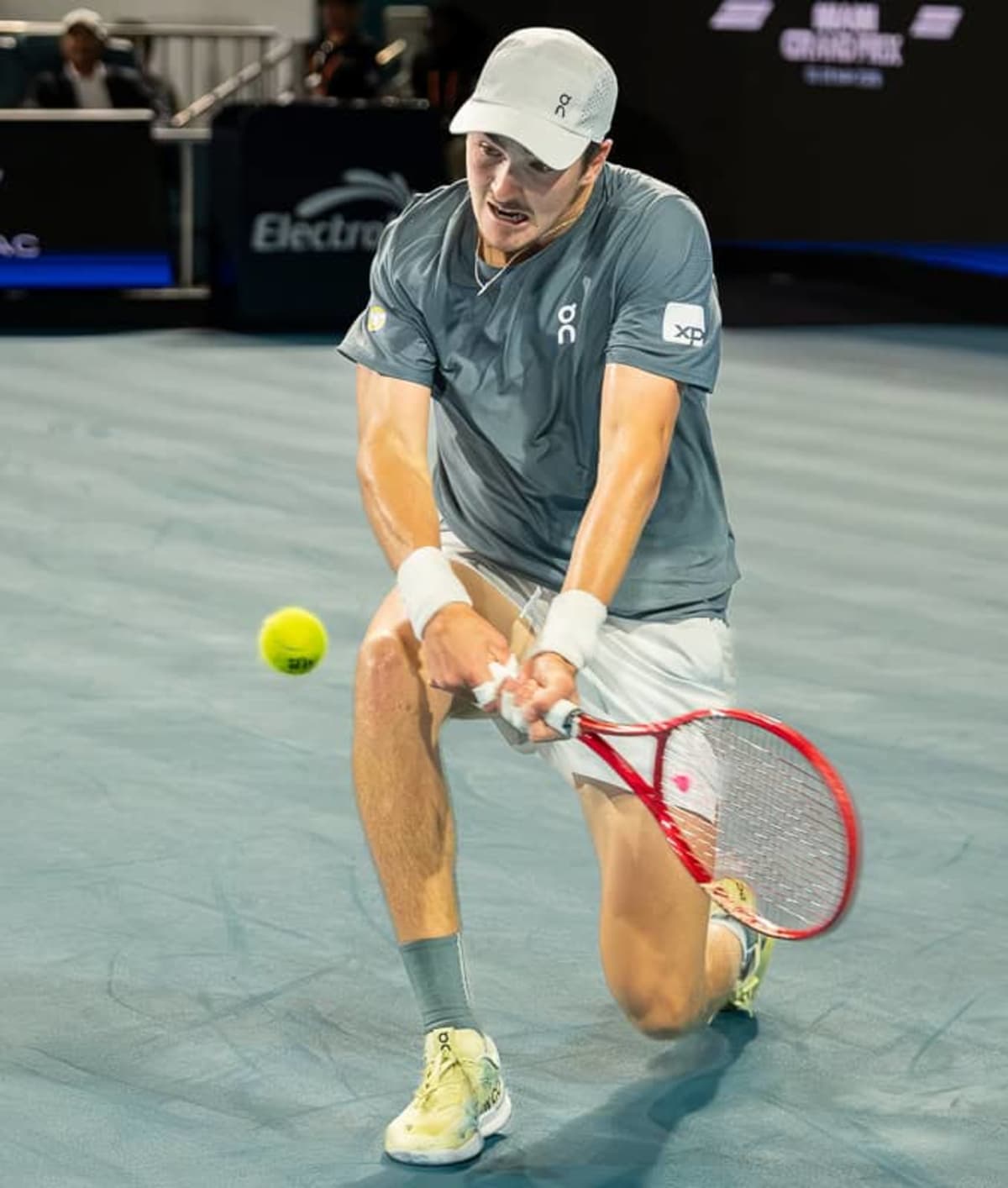Young Brazilian tennis player practices on outdoor court in São Paulo with racket