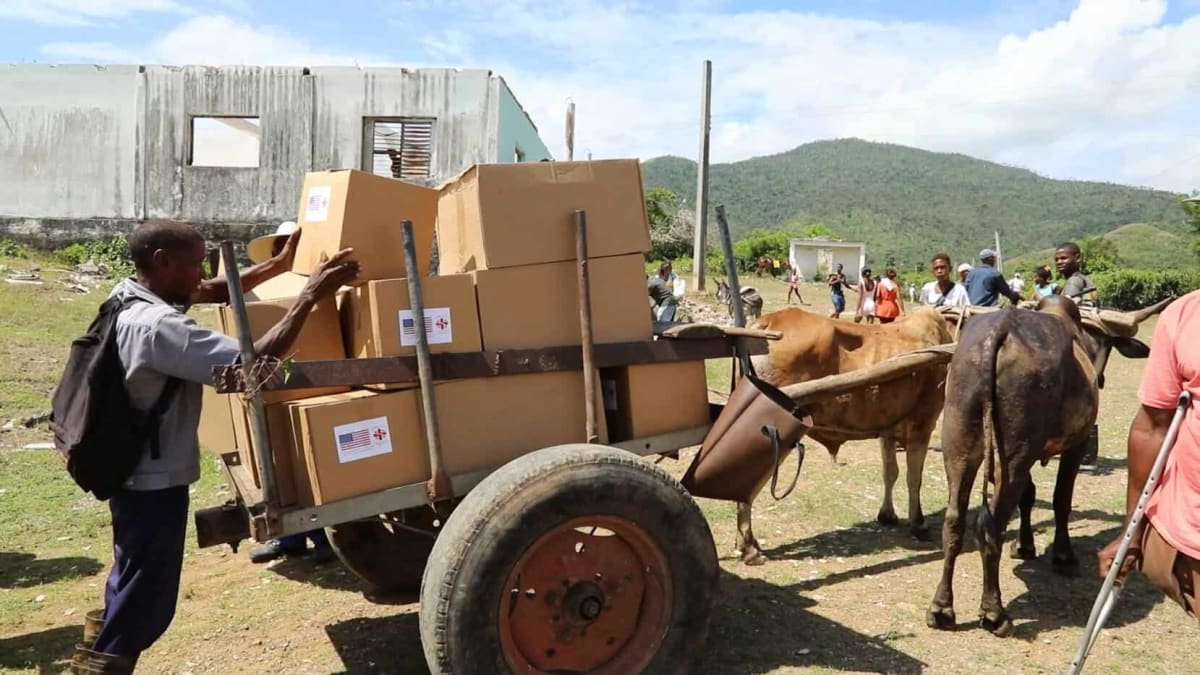 Teodardo Debardet on modified bicycle wheelchair carrying humanitarian aid package in rural Cuba