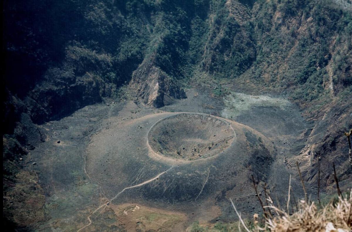 ** Aerial view of El Boquerón volcanic crater surrounded by green forest in El Salvador