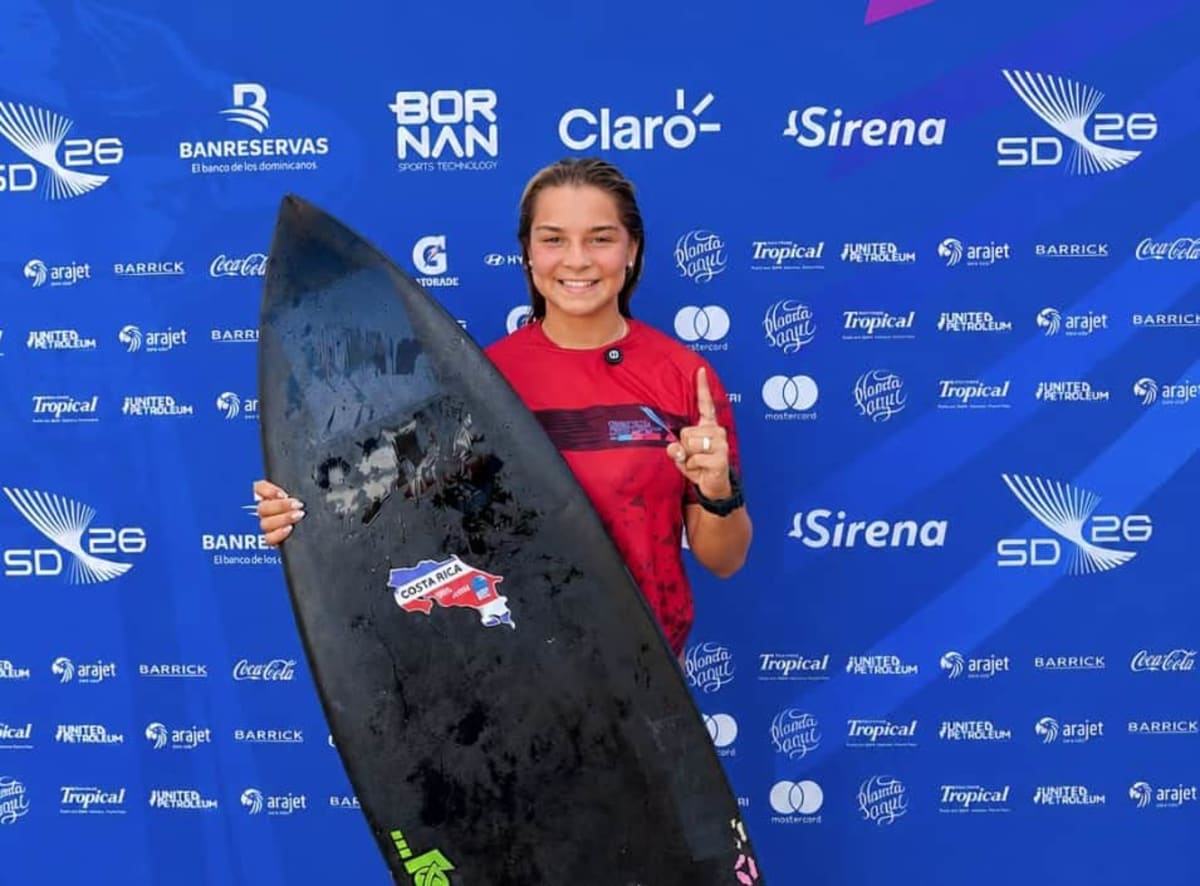 Young Costa Rican surfer Rachel Agüero celebrating on beach after winning gold medal competition