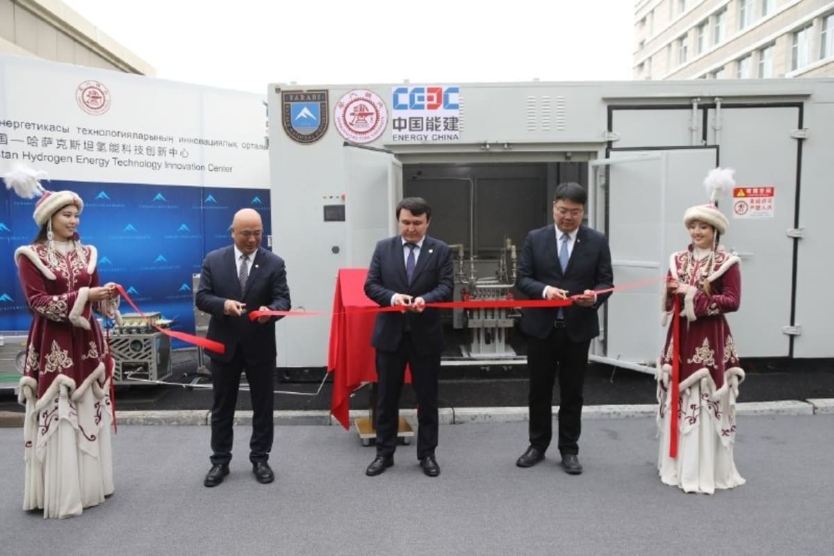 Modern university building with students and officials gathered for hydrogen energy center opening ceremony