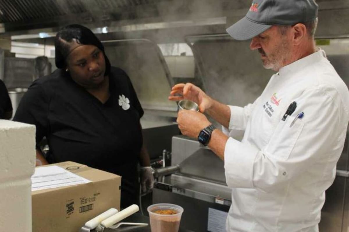 Culinary specialist Michael DuBose training Thomasville High School nutrition staff in kitchen