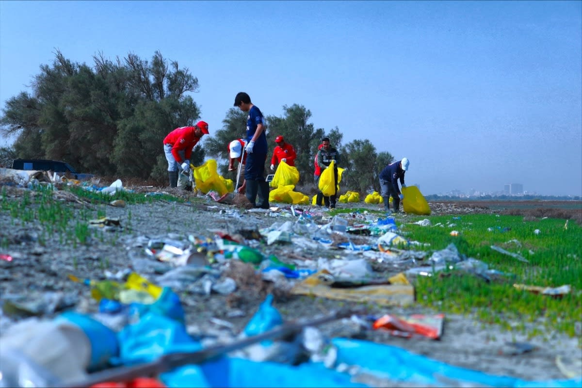 Volunteer divers on boat with collected plastic waste and fishing nets from Kuwait Bay cleanup