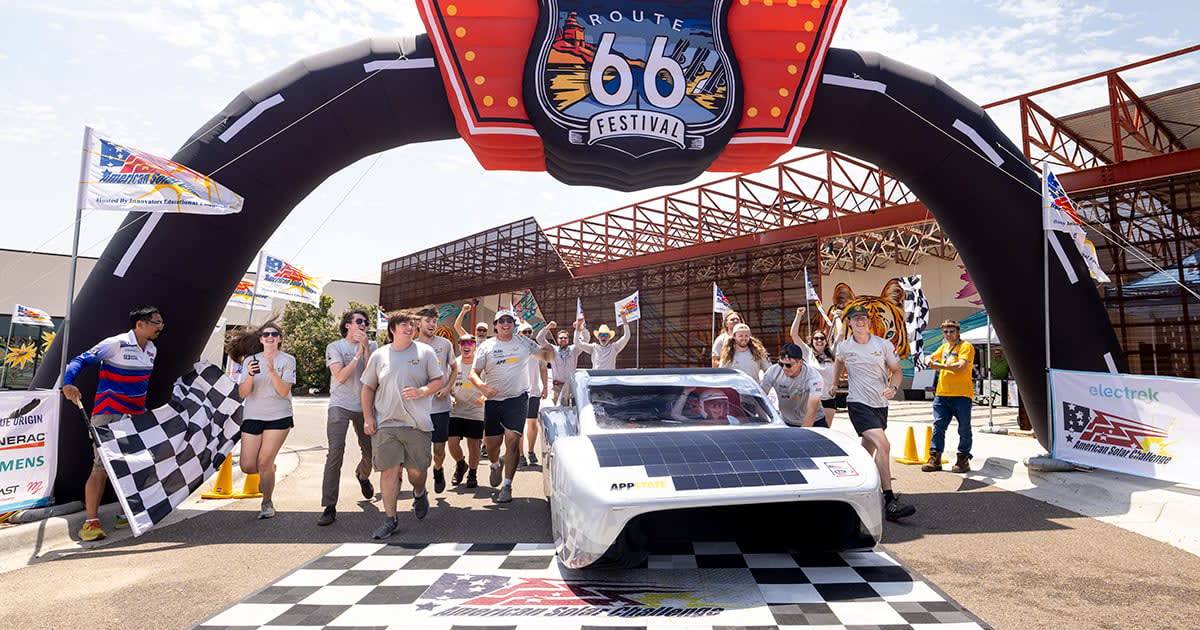 ** Solar-powered car Autumn crossing finish line in Amarillo Texas with Team Sunergy celebrating
