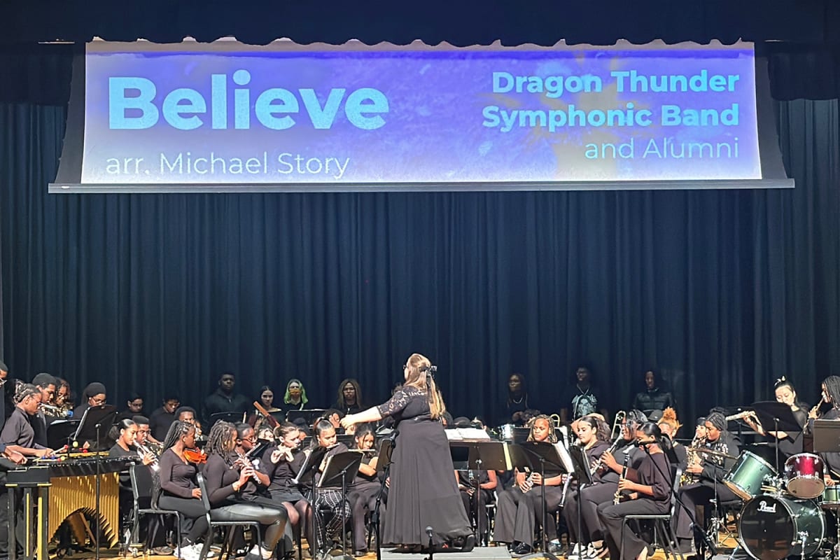 Ellie Campbell smiling with students in music classroom at Connecticut magnet school