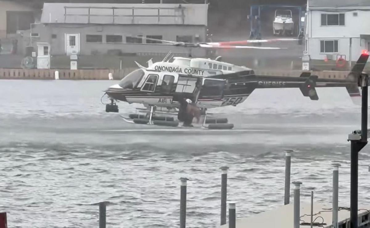 Sheriff's helicopter crew member rescuing goldendoodle from cold river water in Central New York