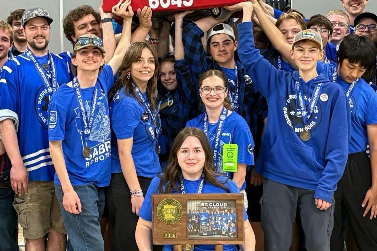 High school students celebrating with their competition robot at Minnesota state robotics championship