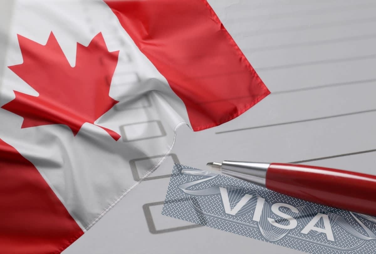 ** Nigerian tech entrepreneur reviewing Canada Start-up Visa Program application documents on laptop