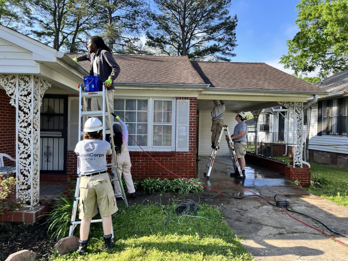 AmeriCorps volunteers repair wooden siding on home through Jackson's Love Your Block program