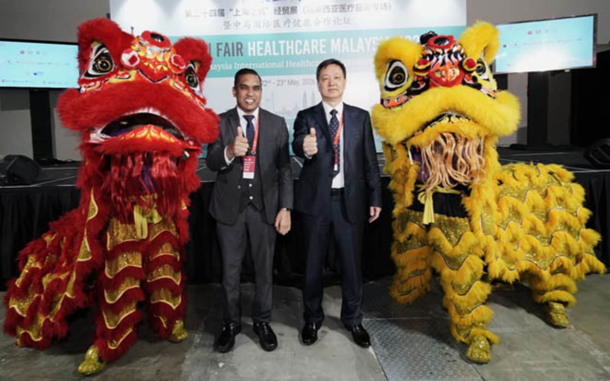 Malaysian and Chinese healthcare officials shake hands at opening ceremony of medical technology exhibition
