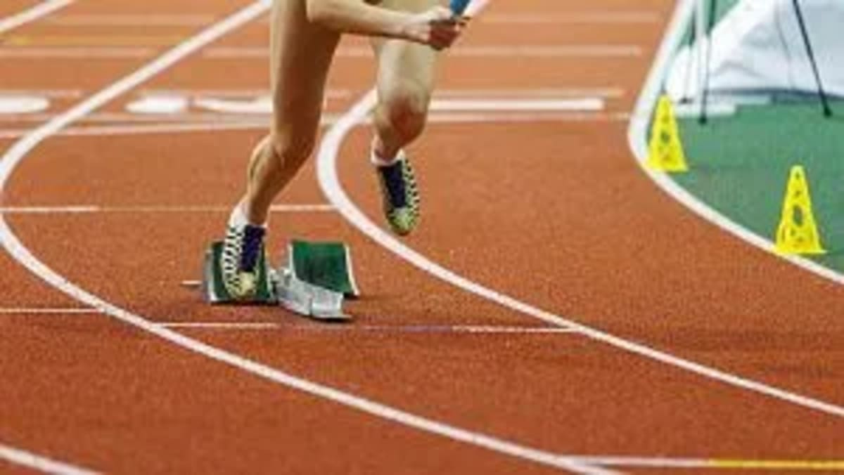 ** Athlete sprinting on indoor track during competitive race at national championship event