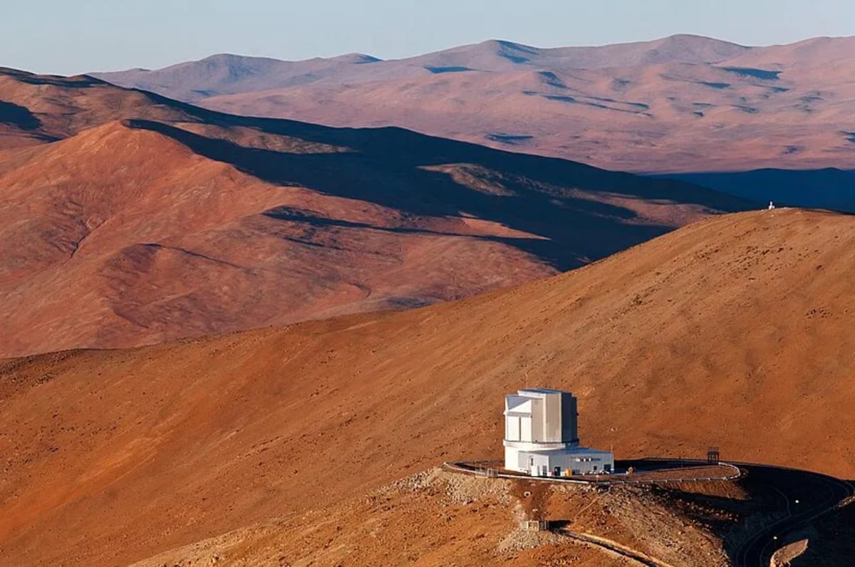 Solar panels and battery storage facility in Chile's Atacama Desert under bright blue sky
