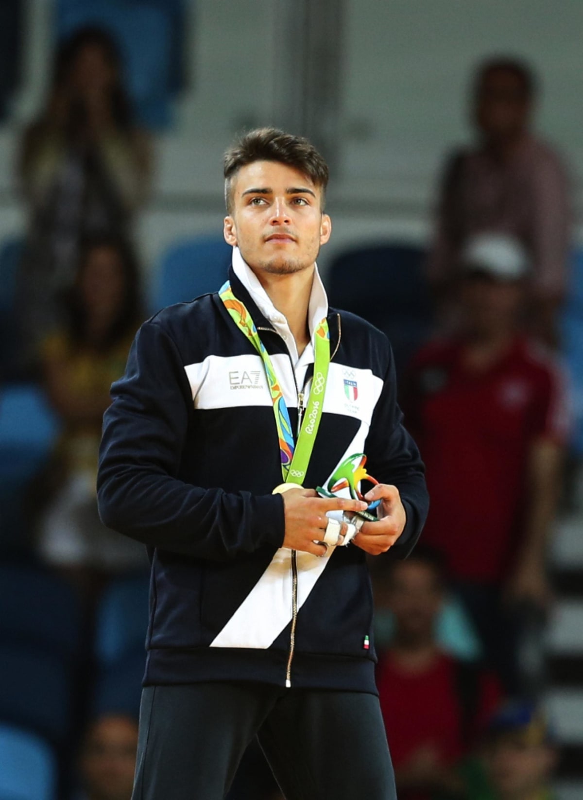 Italian Olympic judo champion Fabio Basile in competition uniform celebrating with raised arms