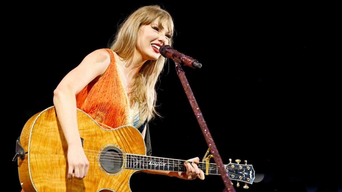 Taylor Swift smiling at music event, celebrating her Nashville Songwriters Hall of Fame honor