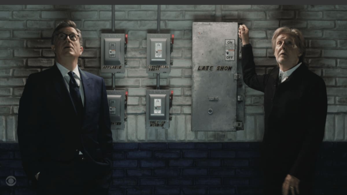 Paul McCartney and Stephen Colbert standing together on Late Show stage smiling