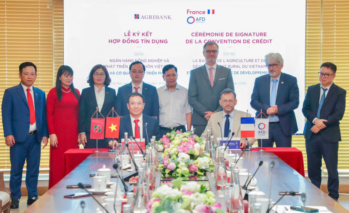 Vietnamese and French officials shake hands at climate finance agreement signing ceremony in Hanoi