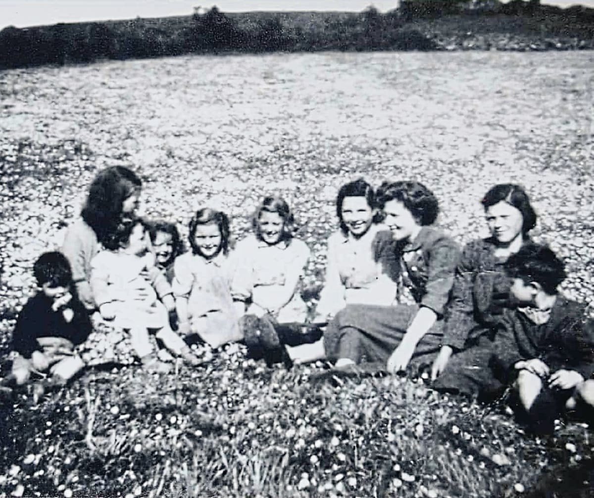 Large multigenerational Irish family gathering together outdoors smiling in rural Tyrone countryside