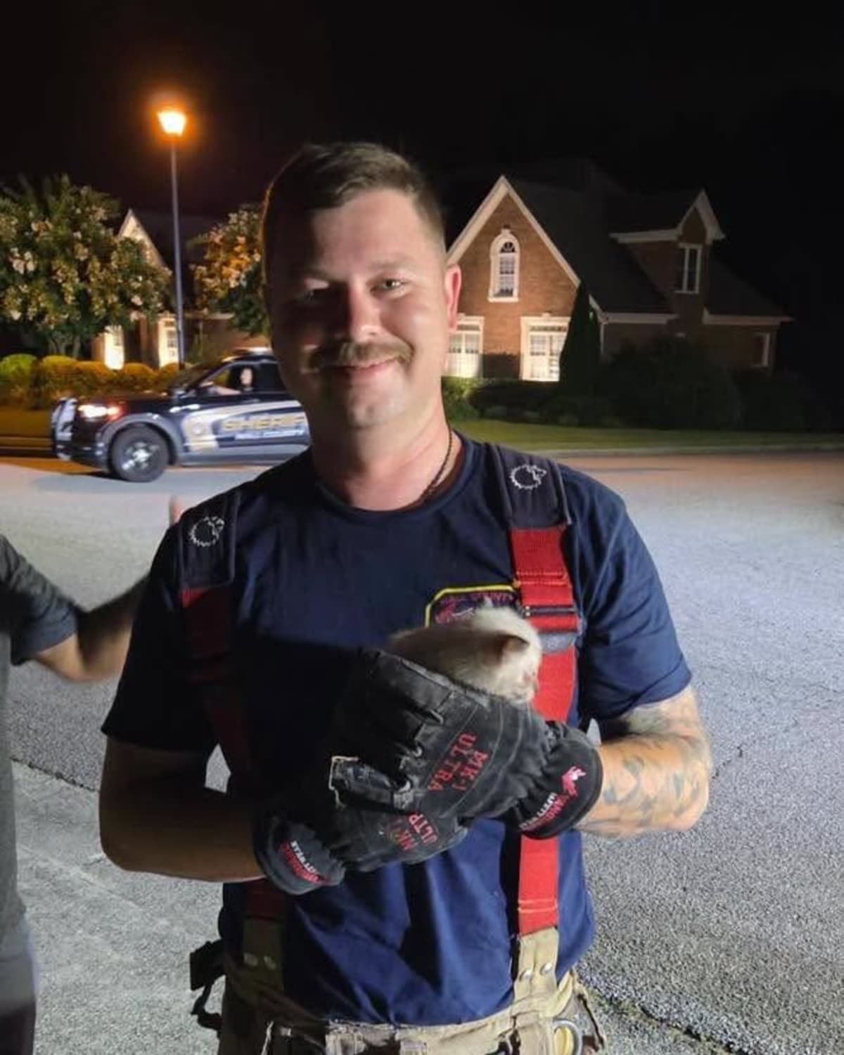 Firefighter holding rescued kitten after storm drain rescue in Hall County Georgia