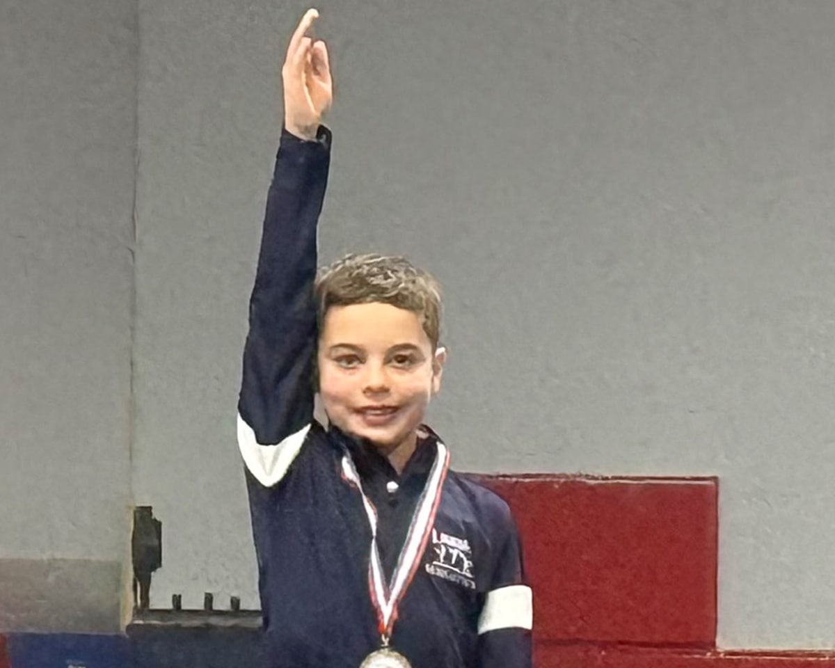 Young boy performing backflip on backyard trampoline during world record attempt